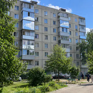 Многоэтажка, где несколько окон с зеркальной пленкой отражают небо (иллюстрация)