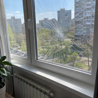 Окно квартиры после удара: стекло треснуло, но держится на пленке (иллюстрация)